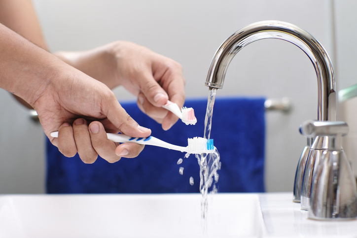 water from sink with toohbrushes