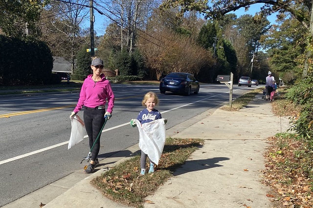 Mother and daughter pick up trash as part of great dunwooy cleanup