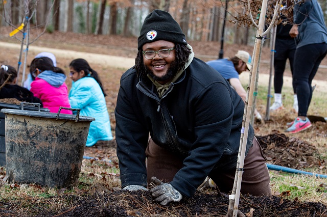 Volunteer planting a tree 2024